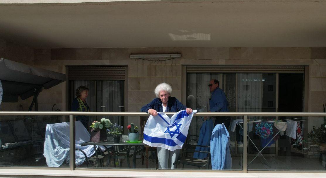 טומרקין מניפה את הדגל ממרפסת ביתה