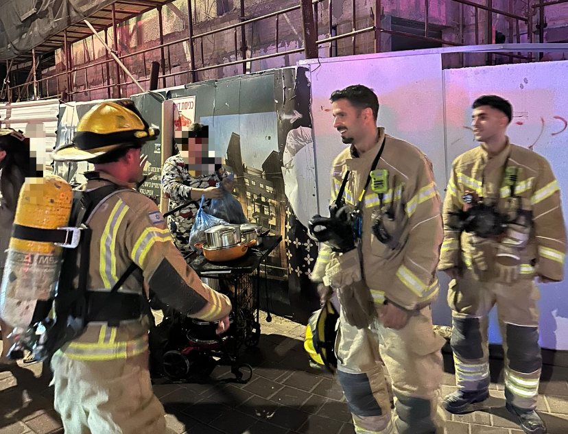 לוחמי האש עם ארוחות השבת שחילצו מהבתים (צילום: כיבוי והצלה אשדוד)