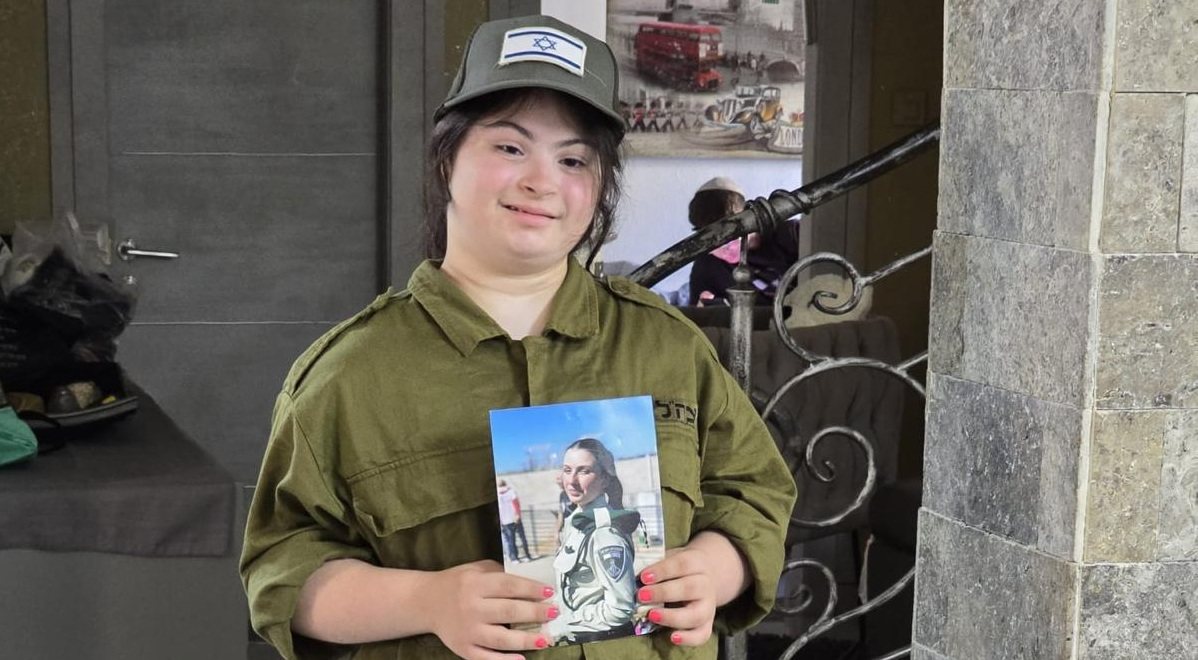 שרה עם תמונת אחותה הגיבורה רווית אסייג הי"ד (באדיבות המשפחה)