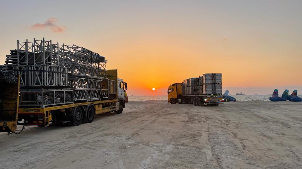 המשאיות עם הציוד בין חוף לידו לקשתות